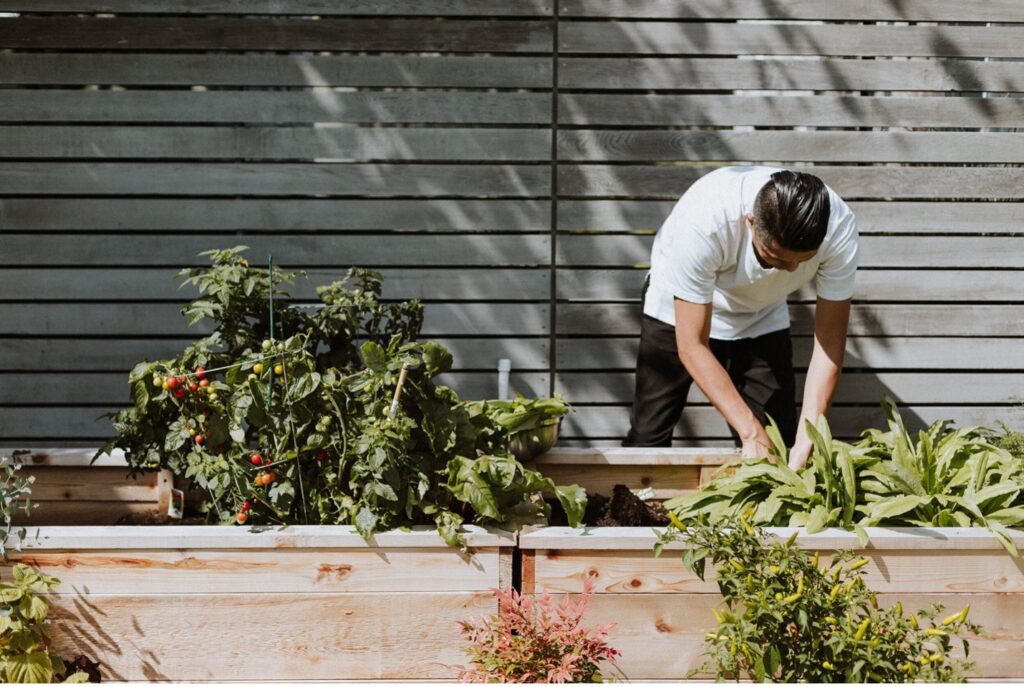 A man working in an urban garden represents the wellness home trends we expect to see in the future