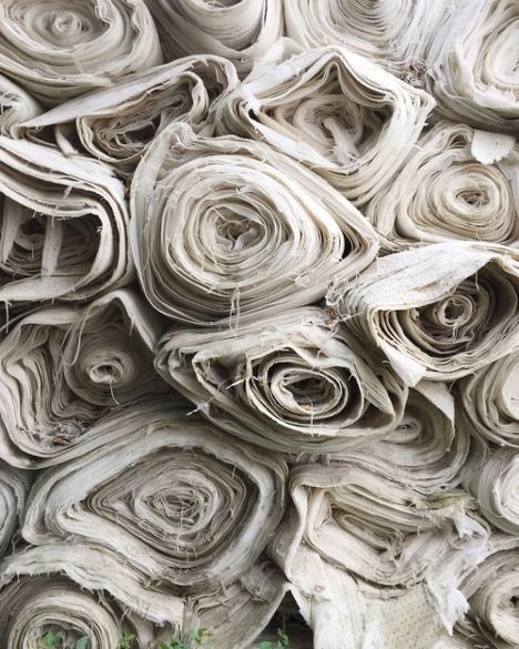 Rolls of raw fabric stacked on top of each other represents the WELL materials concept