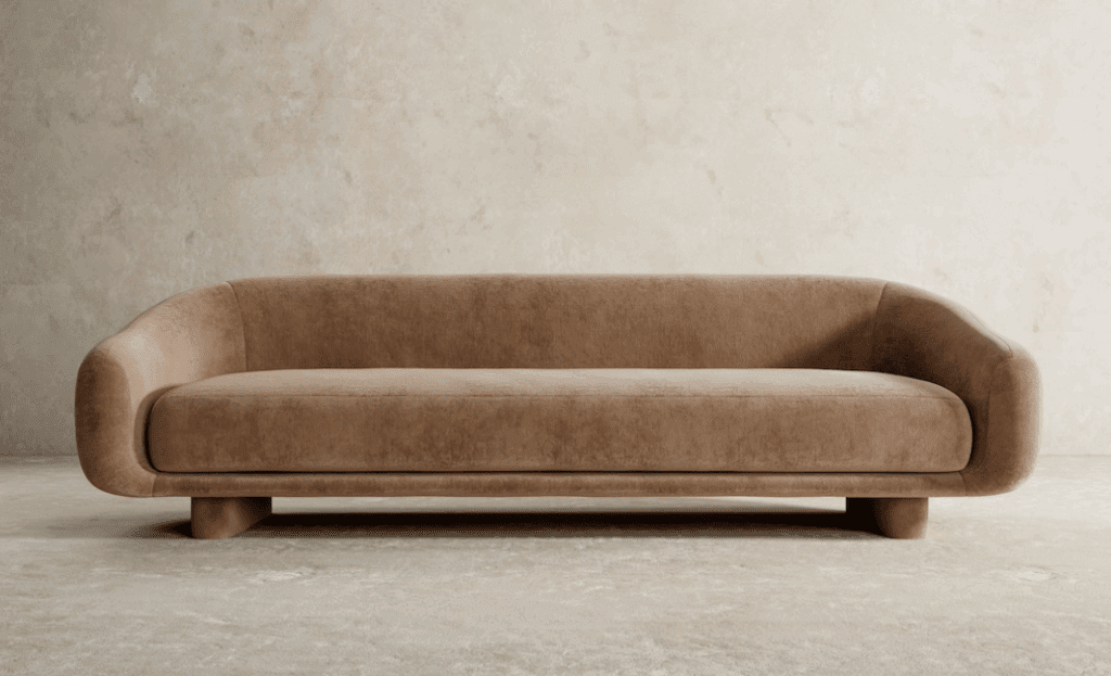 A modern curvy sofa in warm brown velvet highlighting Pantone's colour of the year Mocha Mousse
