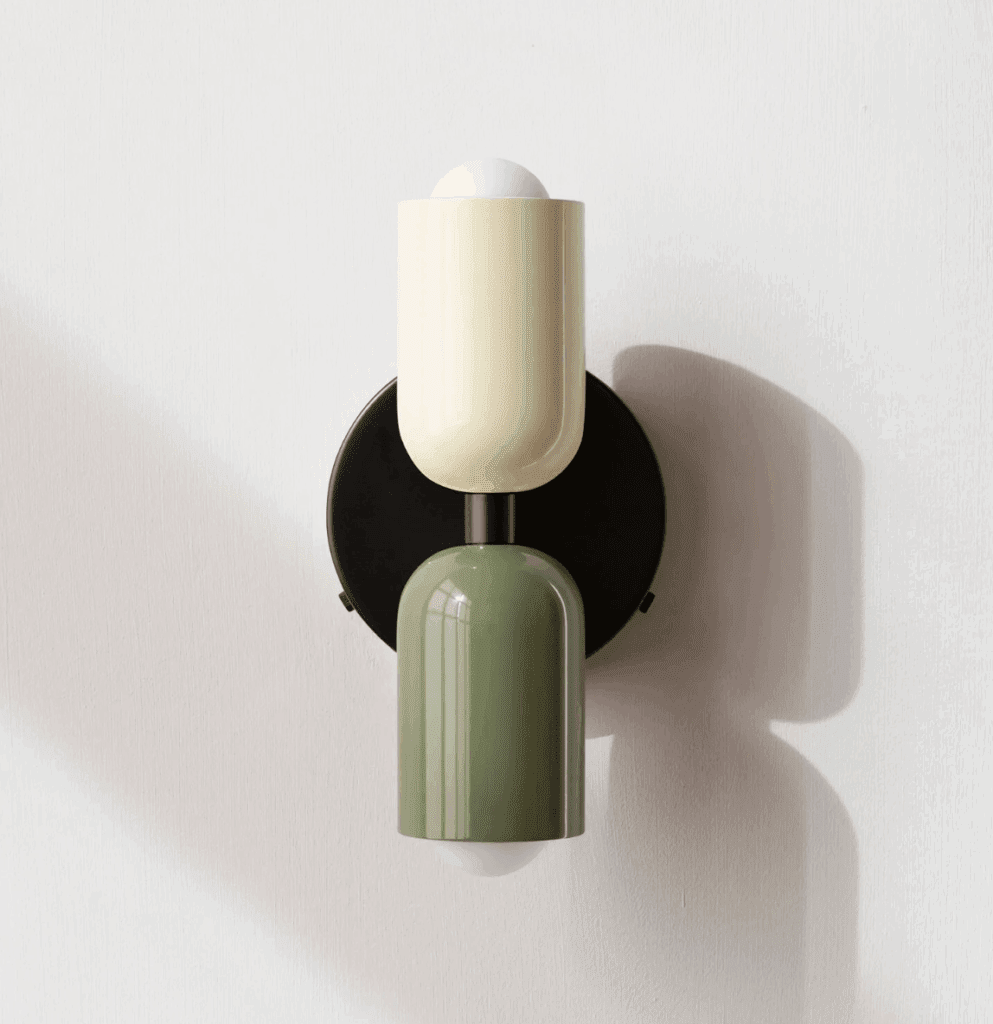 A wall sconce with olive green and cream white shades